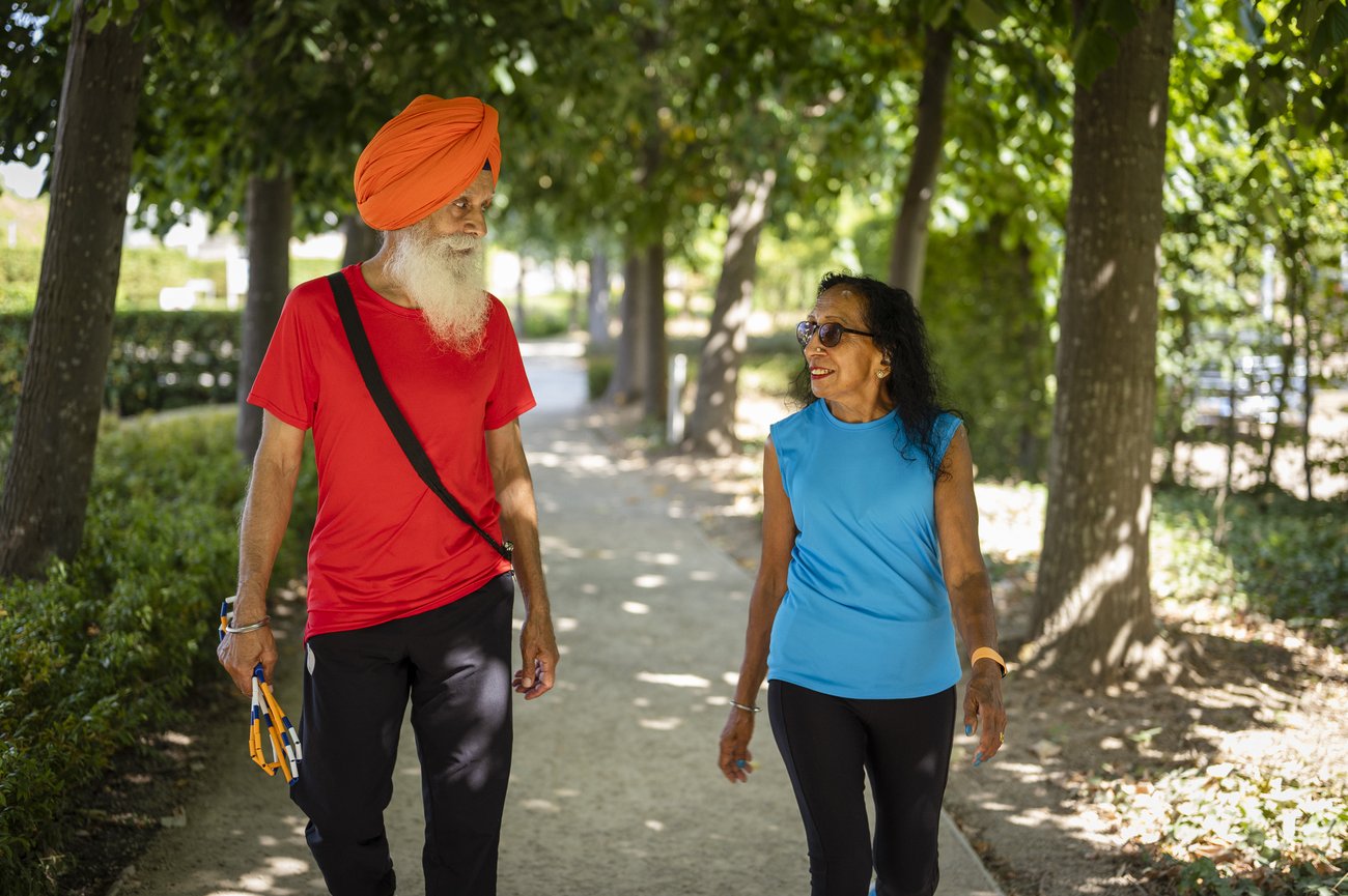 Un couple de personnes âgées marchent dans un parc
